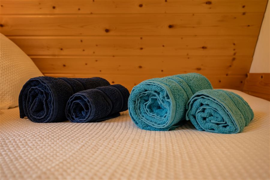 Serviettes roulées préparées sur le lit du chalet romantique Au Doux Altic